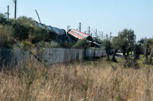 Rescue workers at the scene of a high-speed train collision in Toledo, Spain, with damaged train cars.